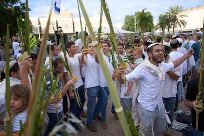Jóvenes israelíes celebran en la plaza de los rehenes. (AP Photo/Ariel Schalit)