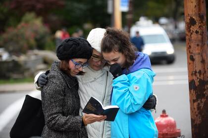 Jóvenes rezan con el libro de oraciones frente a la sinagoga