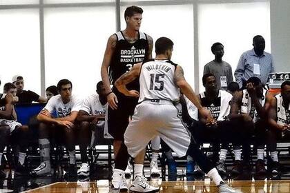 Juampi Vaulet con una bota observando el partido de los Nets ante los Hornets