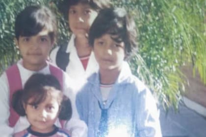 Juan Agustín, a la derecha de la imagen, un primer día de colegio con sus hermanos; tenía una cicatríz cerca de la costilla derecha y en la cabeza