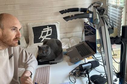 Juan, durante una de las tantas entrevistas laborales desde su casa en Ámsterdam, junto a su gato, que emigró con ellos.