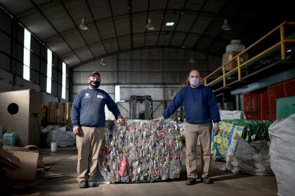 Juan Ignacio Báez y Mario Alagna, de la Cooperativa de Trabajo RSU Ambiental, posan en la planta donde separan y organizan el material reciclable que recolectan en la "Ruta Verde".
