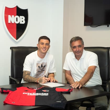 Juan Ignacio Ramírez firma su contrato junto a Ignacio Astore, en enero del año pasado; el presidente negó que Newell's haya castigado a los seis chicos.