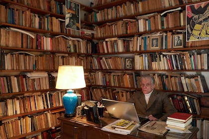 Juan José Sebreli en su estudio, rodeado de libros, fotografías de filósofos y pinturas 