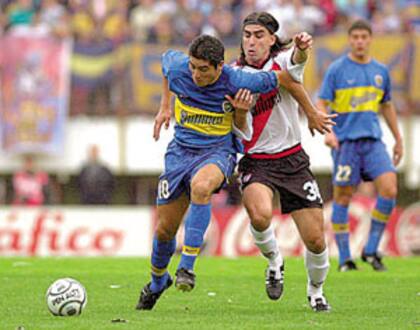 Juan Román Riquelme, en una tarde donde fue la figura del superclásico, se escapa de Claudio Husain, el mejor jugador de River; el volante de Boca brilló en la conducción