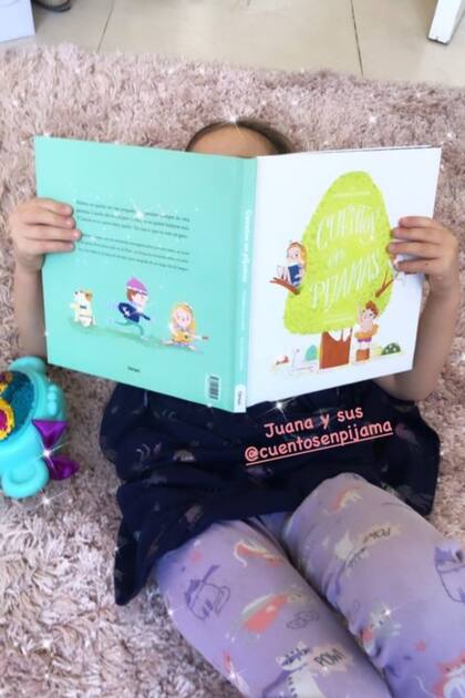 Juana Sieling, hija de Marcela Kloosterboer, leyendo cuentos en la sala de juegos de la familia