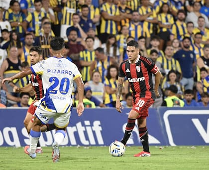 Juanfer Quintero domina la pelota ante la marca de Pizarro