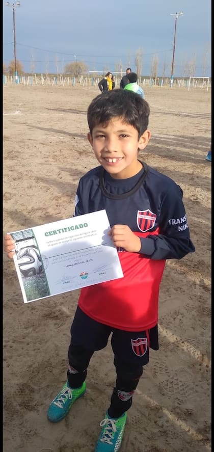 Juanito con un diploma por su buen desempeño jugando al fútbol