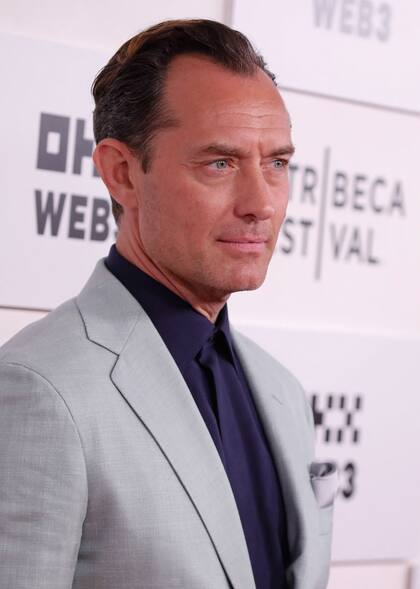 Jude Law posó para los fotógrafos enfundado en un traje gris de Brioni que combinó con una camisa azul; fue de los más elegantes de la velada