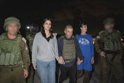 Judith Raanan (derecha) y su hija Natalie, de 17 años, son escoltadas por soldados israelíes y Gal Hirsch, coordinador especial del primer ministro Benjamin Netanyahu para la devolución de los rehenes, cuando regresan a Israel desde cautiverio en la Franja de Gaza (AP)