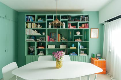 Juego de comedor de metal con mesa irregular (Studio Petra) y biblioteca hecha a medida como gran protagonista