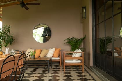 Juego de living exterior (L’Épicerie). Los almohadones (Tienda de Costumbres), en los mismos tonos que el mantel de Petite Affaire.