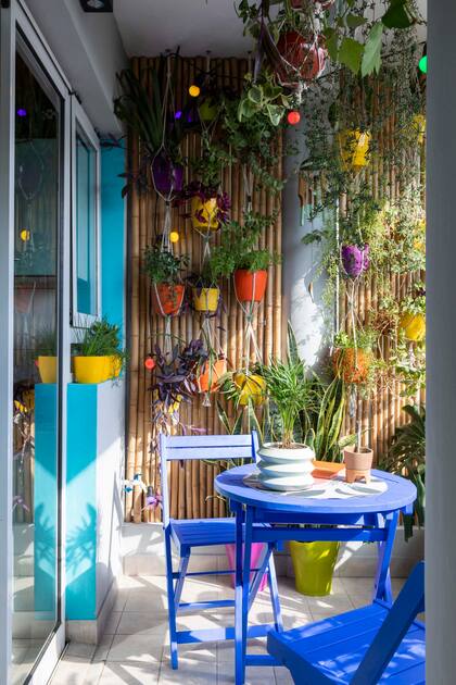 Juego de mesa y sillas pintadas en azul eléctrico (Oh My Chalk!). Guirnalda de luces (Etheos). Macetas (Coco Cerámica).