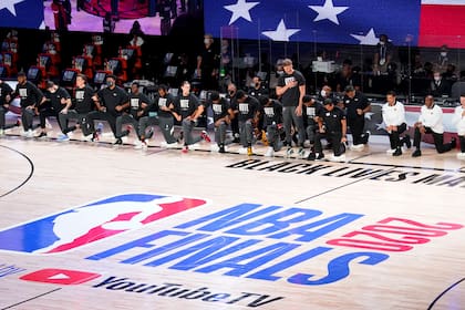 Jugadores de Miami Heat se arrodillan (de pie: Meyers Leonard) durante el Himno Nacional de los Estados Unidos.