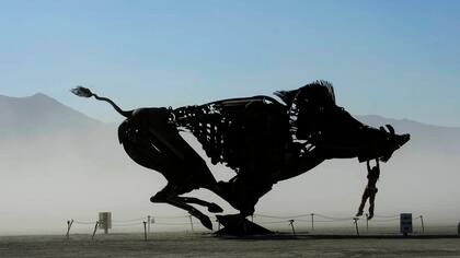 Jugando en una escultura interactiva de un jabalí en una mañana de polvo en Burning Man