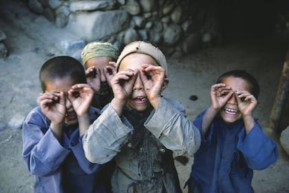 Jugar al espejito. Niños afganos se divierten mientras imitan al fotógrafo, en una imagen de 1985. Reza Deghati pasó su vida retratando las calles y la gente de los lugares más crudos donde, a través de su cámara, busca cambiar la realidad
