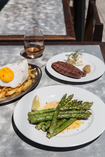 Jugosos espárragos asados, salchicha de cerdo y tocino con mostaza de Dijon, papa y huevo.