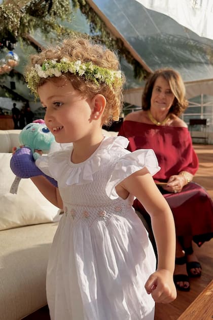 Julia, la más chica
de la familia, llevó un soñado vestido
de Malena Smock con una corona de
flores, al igual que su hermana mayor.
Detrás, Lizzie, la mamá de Macedo