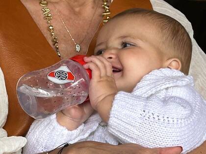 Julia sonriendo con su mamadera de River Plate