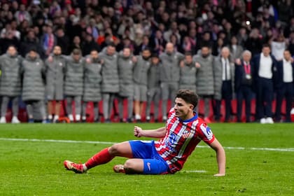 Julián Álvarez del Atlético de Madrid se resbala tras ejecutar un disparo en la tanda de penales ante el Real Madrid en los octavos de final de la Liga de Campeones, el miércoles 12 de marzo de 2025. (AP Foto/Manu Fernández)