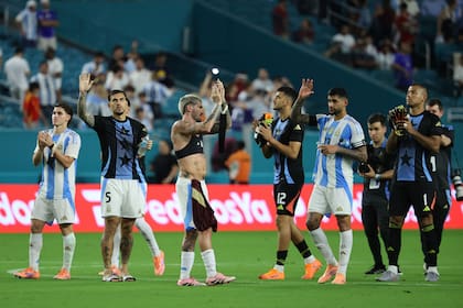 Julián Alvarez, Leandro Paredes, Rodrigo De Paul y Cristian Romero, que no están en duda para el Mundial, saludan tras la victoria amistosa; con ellos, los arqueros suplentes Gerónimo Rulli y Walter Benítez.