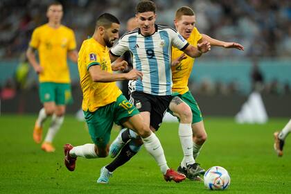 Julián Álvarez lucha por la pelota con Aziz Behich y Kye Rowles durante el partido que disputan Argentina y Australia, por los octavos de final de la Copa del Mundo Qatar 2022 en el estadio Ahmed bin Ali, Umm Al Afaei, Qatar, el 3 de diciembre de 2022.
