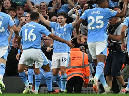 Julián Álvarez ríe, sus compañeros van a buscarlo. Transita su segunda temporada en Manchester City