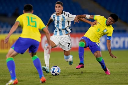 Julián Fernández desplaza a Andrey Santos mientras otro rival lo espera de frente