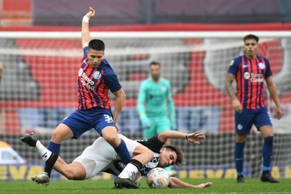 Julián Palacios trata de controlar la pelota con Cristian Vega, el mejor de Central Córdoba, en el piso