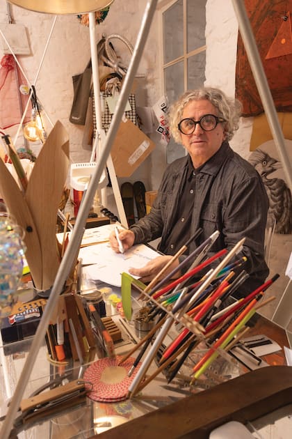 Julio en el estudio, un lugar reservado para la creación. Allí se apilan lápices, materiales diversos, libros, revistas y objetos que sirven como fuentes de inspiración.