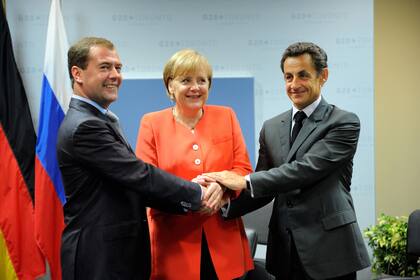 El expresidente francés Nicolás Sarkozy y el exmandatario ruso Dmitri Medvedev junto con la canciller alemana durante un encuentro trilateral en el marco de la cumbre del G-20 en Toronto