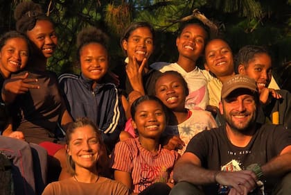 Junto a Cande, su pareja, y un grupo de niños en una visita a la obra del padre Opeka en Madagascar.