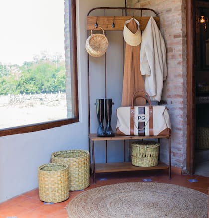 Junto a la puerta de ingreso se armó un pequeño mud room con un recibidor en hierro y madera de paraíso (Hilos en Sueños), sobre una pared que se pintó de gris claro.