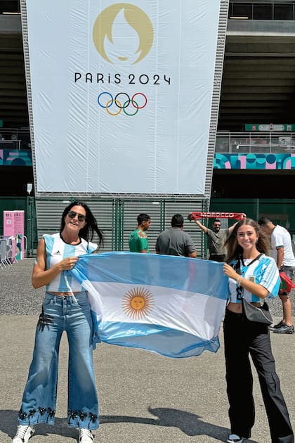 Junto
a su nuera Irene y la bandera argentina antes del
primer partido que jugó el
seleccionado nacional.