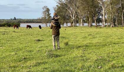 Junto a su pequeño hijo recorriendo el lote a la vera del río Uruguay