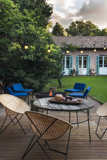 Junto al fogonero, guirnalda con lámparas led inalámbricas (Electro Tucumán) y una mesita con tabla de madera artesanal (Fundación Niwok).