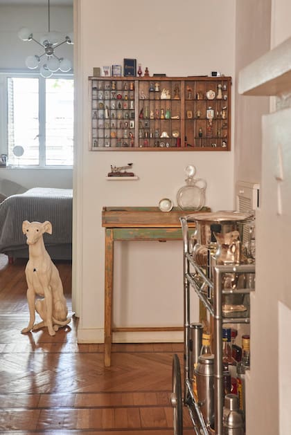 Junto al galgo, su mueble más querido: un antiguo pupitre que estuvo años en el taller mecánico de su padre y hoy usa para guardar su juego de cubiertos. Sobre él, un viejo cajón tipográfico que expone miniaturas de todo el mundo.