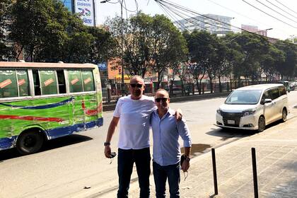 Junto a un compañero de trabajo en Dhaka, Bangladesh. Los colectivos siempre están rayados por los roces y golpes durante los recorridos llenos de autos.