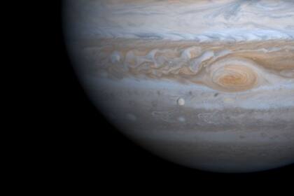 Jupiter y, en el borde inferior izquierdo de la gran mancha roja, Europa, que está a 600 km de la capa superior de nubes del planeta