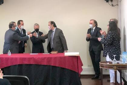 Pablo Bertuzzi y Mariano Llorens saludan a Roberto Boico. Los demás miembros de la Cámara aplauden