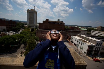Justin Coleman, de Birmingham, Alabama, usa sus gafas para mirar un eclipse solar desde la parte alta de una estructura de estacionamiento el lunes 21 de agosto de 2017, en Birmingham. (AP Foto/Brynn Anderson, Archivo)