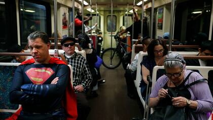 Justin Harrison, imitador de superhéroes viaja en el tren, vestido con un traje de Superman en su camino a Hollywood Boulevard en Los Ángeles