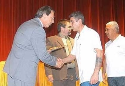 Justo José López (el hombre con canas, a la derecha), durante un acto del Servicio Penitenciario Bonaerense, en 2008. Ese día recibió de manos del entonces ministro de Justicia, Ricardo Casal, el primer premio del programa "Encarcelarte" por una escultura hecha en madera y bautizada "