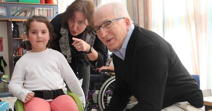 Kaplan junto a una de las niñas que recibió la silla