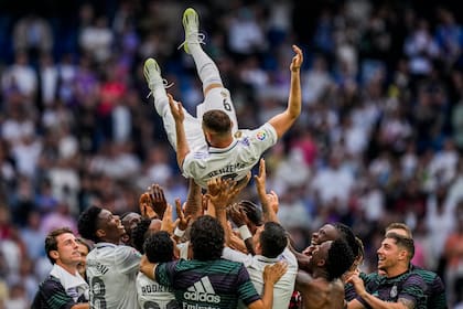Karim Benzema del Real Madrid es alzado por sus compañeros tras el empate 1-1 contra el Athletic Bilbao en la Liga española, el domingo 4 de junio de 2023, en Madrid. (AP Foto/Bernat Armangue)