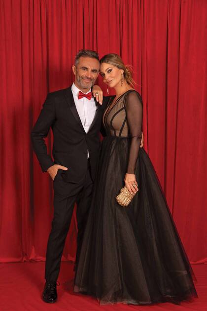  Karina Mazzocco –con vestido de mangas transparentes y gran falda de la diseñadora Nuria Bueno– posó junto a su marido, el corredor de autos, Omar El Bacha, con quien son padres de Malek. 