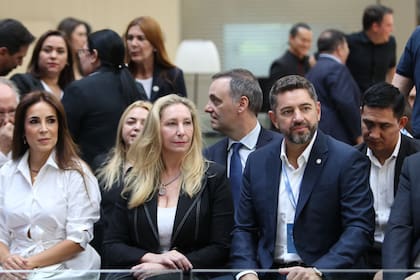Karina Milei en la actividad de la FIFA; atrás, Manuel Adorni