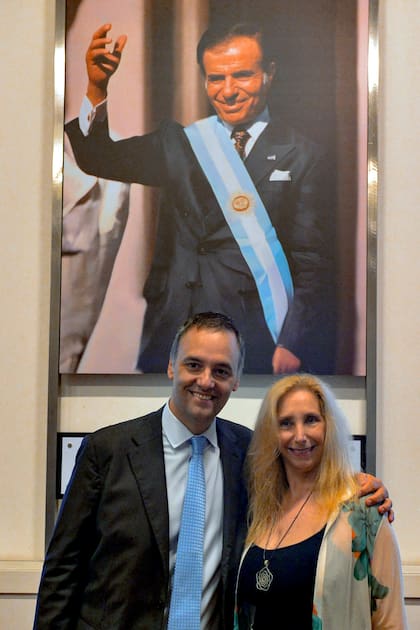 Karina Milei y Manuel Adorni frente a la imágen de Carlos Saúl Menem