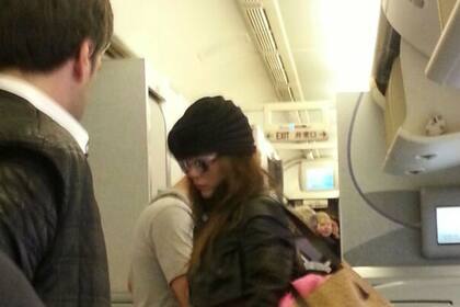 Karina y el misterioso joven de espaldas, a punto de bajar del avión