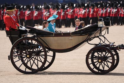 Kate compartió asiento con Charlotte en el Ascot Landau en el que llegó a Buckingham. La princesita, que tiene 10 años lució un vestido que repetía la paleta del traje de su mamá y que acompañó con el broche herradura que había llevado en el funeral de su bisabuela Isabel. En el asiento delantero viajaban los príncipes George (11) y Louis (7).